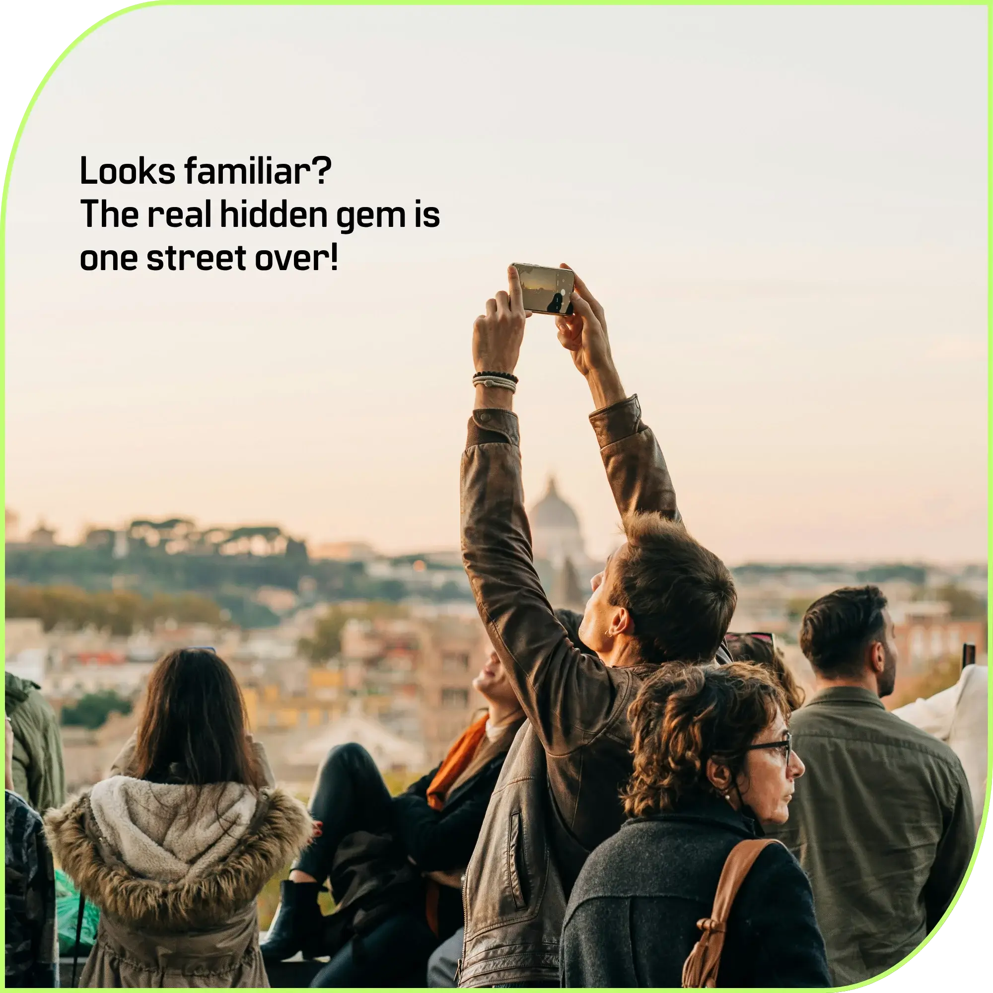 2B LOCAL app: Group of people in coats raise phones to capture a cityscape at sunset from a viewpoint, arms raised in the air.